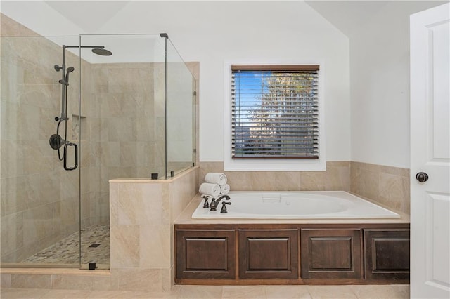 bathroom featuring tile patterned flooring, separate shower and tub, and vaulted ceiling