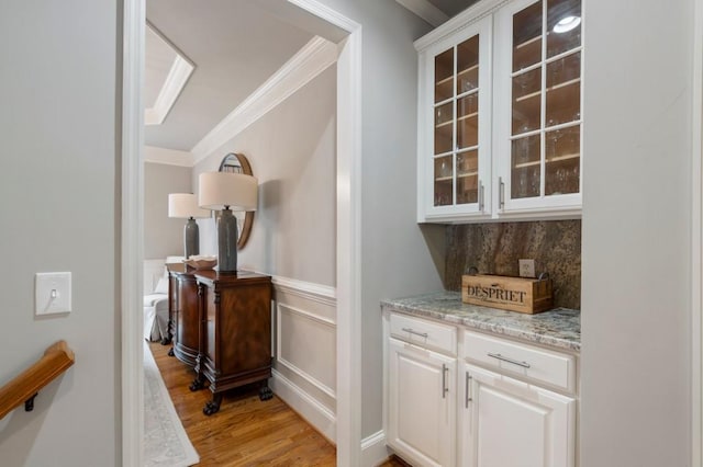 4250 Old Oak Trce, Cumming, GA 30041 - bar featuring crown molding, light wood-type flooring, wainscoting, backsplash, and a decorative wall