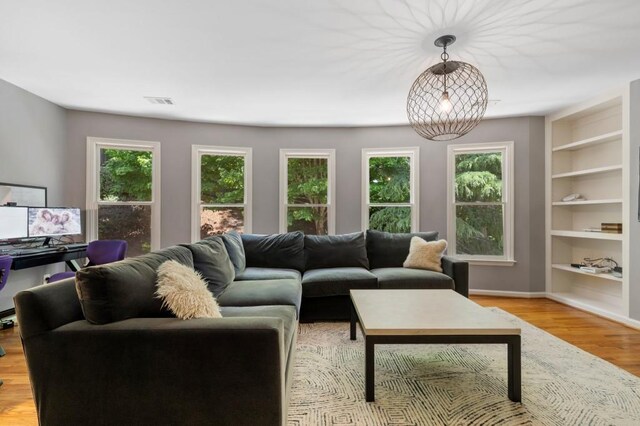 4250 Old Oak Trce, Cumming, GA 30041 - living area with built in shelves, light wood-style floors, and baseboards