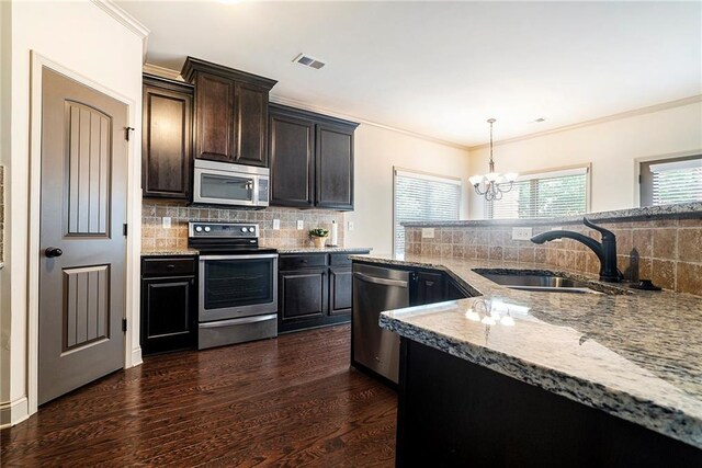 3175 Rock Port Cir, Norcross, GA 30092 - kitchen featuring appliances with stainless steel finishes, a sink, light stone countertops, decorative backsplash, and a chandelier