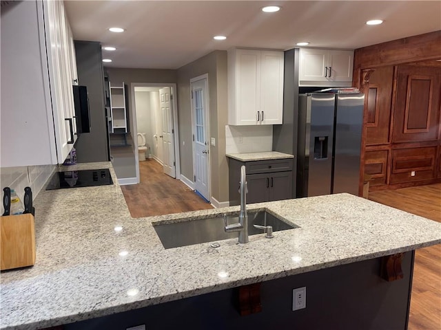 1321 Earle Ct SE, Conyers, GA 30013 - kitchen featuring stainless steel fridge with ice dispenser, black electric stovetop, a sink, wood finished floors, and recessed lighting