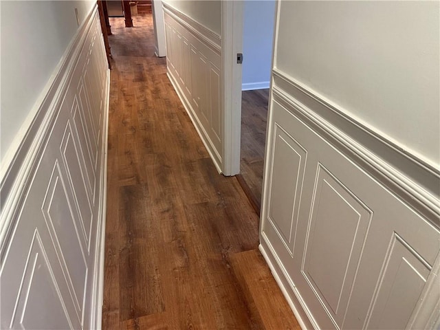 1321 Earle Ct SE, Conyers, GA 30013 - hallway featuring dark wood-style flooring, a decorative wall, and wainscoting