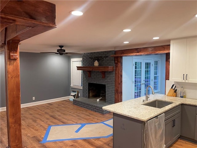 1321 Earle Ct SE, Conyers, GA 30013 - kitchen with a sink, french doors, baseboards, light wood finished floors, and light stone counters