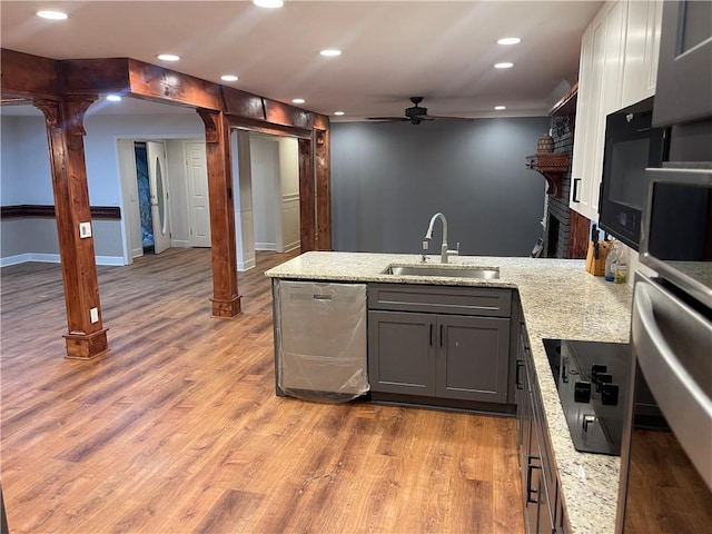 1321 Earle Ct SE, Conyers, GA 30013 - kitchen with a sink, stainless steel dishwasher, a ceiling fan, decorative columns, and a peninsula