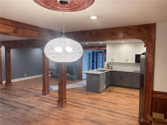 1321 Earle Ct SE, Conyers, GA 30013 - kitchen with a sink, gray cabinetry, a peninsula, light wood-style flooring, and recessed lighting