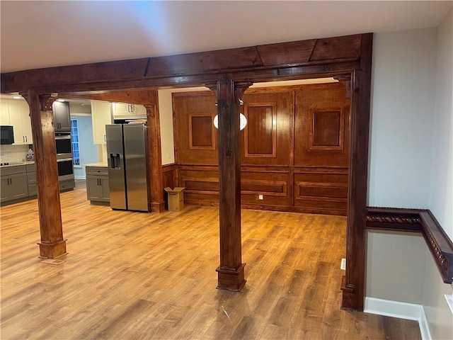 1321 Earle Ct SE, Conyers, GA 30013 - below grade area featuring stainless steel refrigerator with ice dispenser and light wood-style flooring
