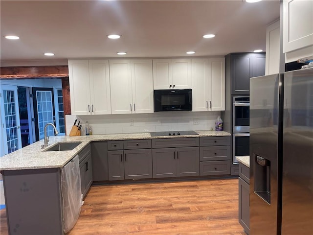 1321 Earle Ct SE, Conyers, GA 30013 - kitchen featuring black appliances, a sink, a peninsula, gray cabinets, and light wood-style flooring