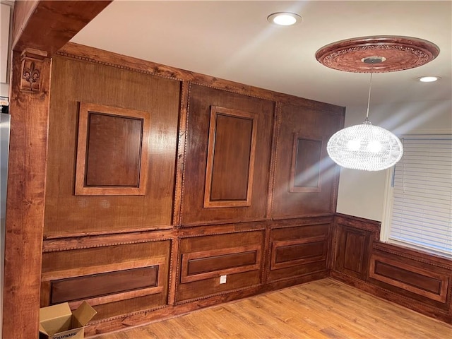 1321 Earle Ct SE, Conyers, GA 30013 - detailed view of a chandelier, wood finished floors, a decorative wall, and wainscoting