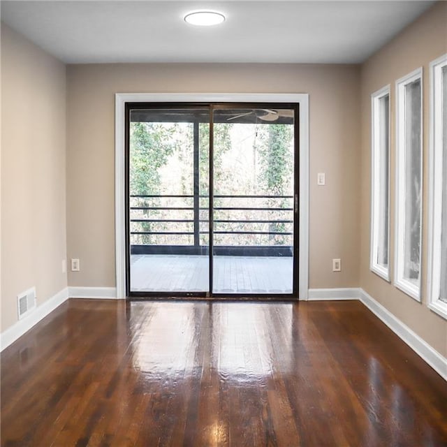 unfurnished room with a wealth of natural light, visible vents, and baseboards