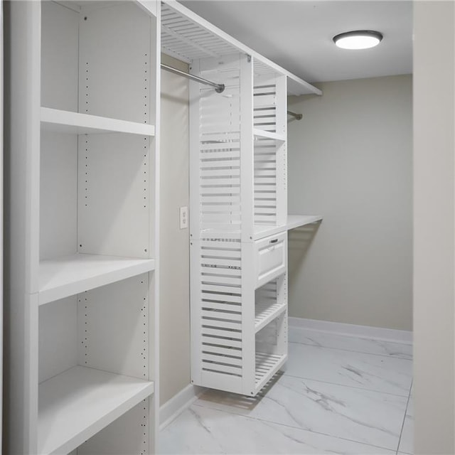 walk in closet with marble finish floor