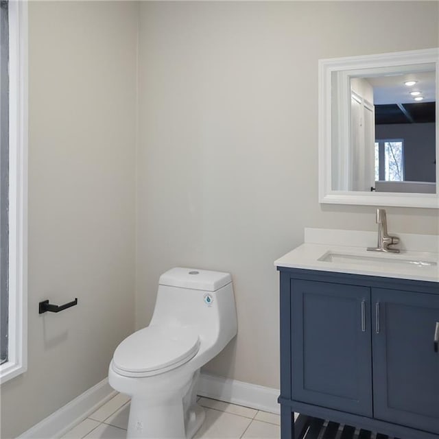 bathroom featuring baseboards, vanity, toilet, and tile patterned floors