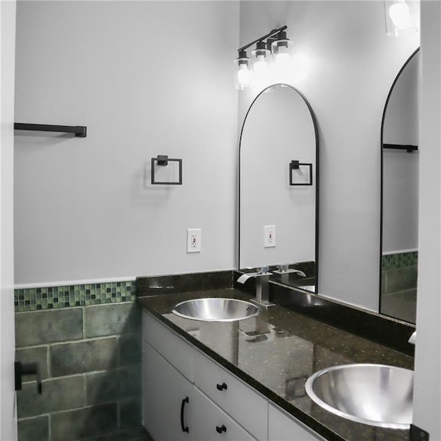 full bathroom with double vanity, tile walls, and a sink