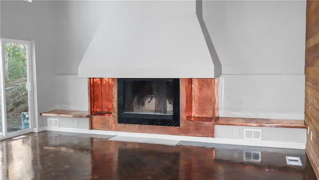 interior details with visible vents and a glass covered fireplace