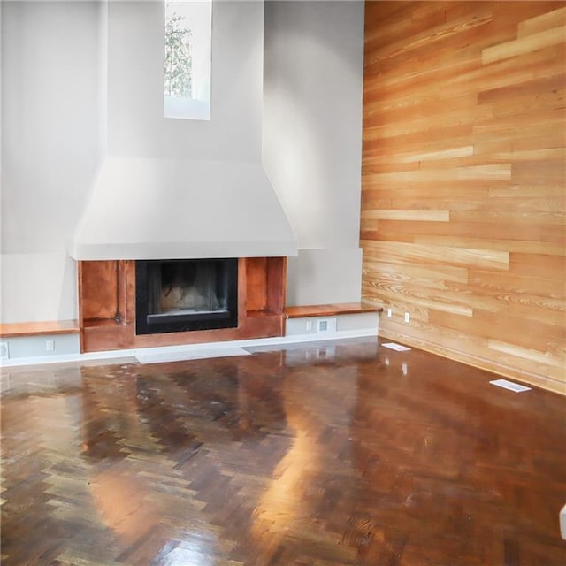 unfurnished living room featuring wood walls and a fireplace