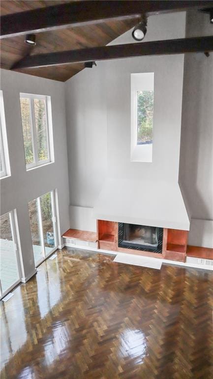 unfurnished living room featuring high vaulted ceiling, beamed ceiling, and a high end fireplace