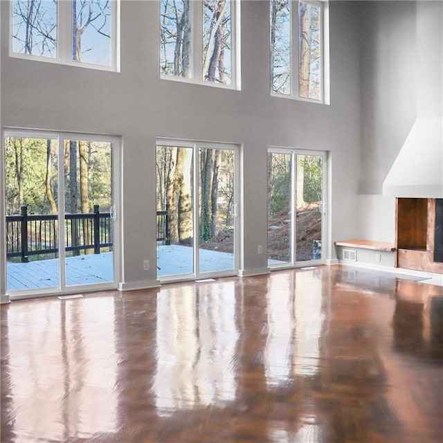 unfurnished living room with a high ceiling and baseboards