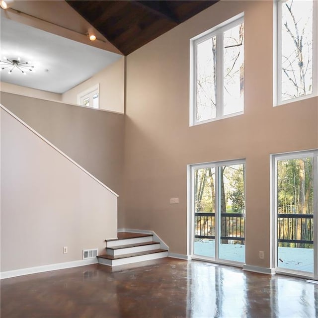 unfurnished living room with plenty of natural light, visible vents, and baseboards