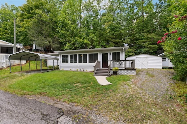 view of front of property featuring a wooden deck, a front lawn, a shed, and a carport