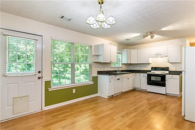 24 Arrow Ct, Lavonia, GA 30553 - kitchen with white appliances, under cabinet range hood, a chandelier, dark countertops, and a textured ceiling