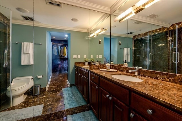 bathroom featuring a shower with door, crown molding, vanity, and toilet