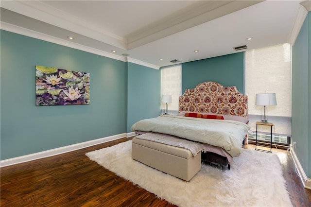 bedroom featuring hardwood / wood-style flooring, a baseboard radiator, ornamental molding, and a tray ceiling