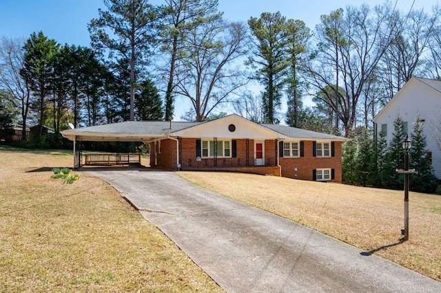 single story home featuring an attached carport, a front lawn, brick siding, and driveway