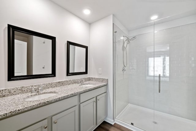 bathroom with vanity, hardwood / wood-style flooring, and a shower with shower door