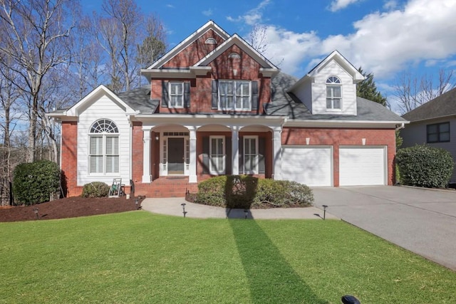 view of front of property with brick siding, covered porch, an attached garage, driveway, and a front lawn