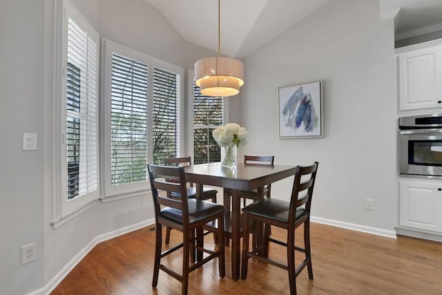 dining room with vaulted ceiling, baseboards, and wood finished floors