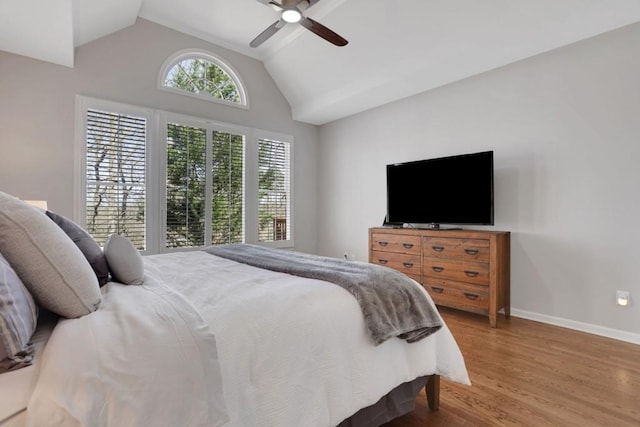 bedroom with a ceiling fan, vaulted ceiling, baseboards, and wood finished floors