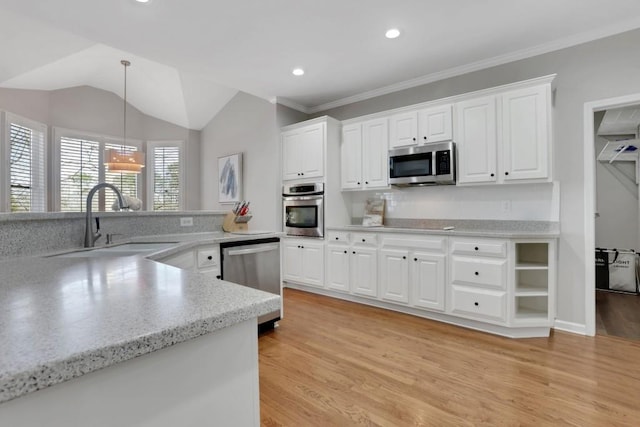 kitchen featuring a sink, white cabinetry, appliances with stainless steel finishes, light wood-type flooring, and pendant lighting