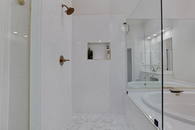 bathroom featuring a garden tub, a tile shower, and vanity