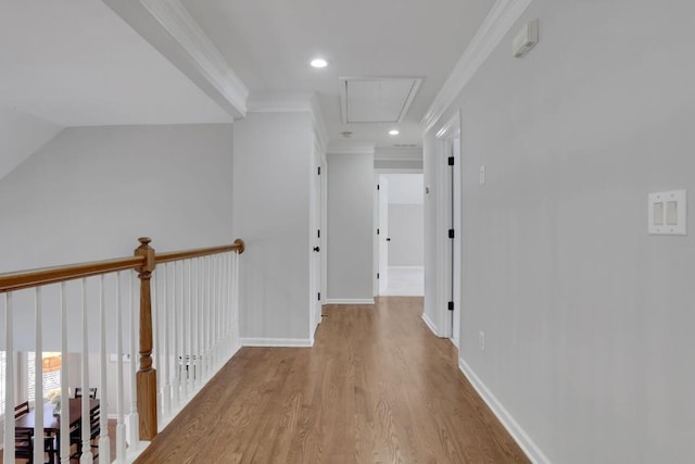 corridor with attic access, baseboards, wood finished floors, crown molding, and recessed lighting