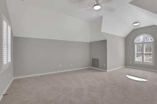 additional living space featuring ceiling fan, lofted ceiling, visible vents, baseboards, and carpet