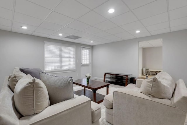 living room with recessed lighting, a paneled ceiling, baseboards, and wood finished floors