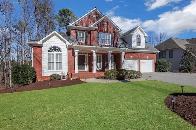 view of front of property with covered porch, brick siding, and a front yard