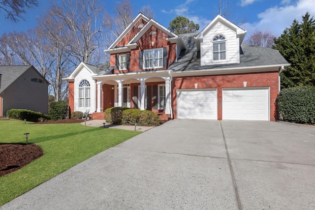 view of front of property with driveway, an attached garage, covered porch, a front lawn, and brick siding