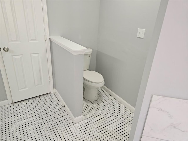 bathroom with baseboards and toilet