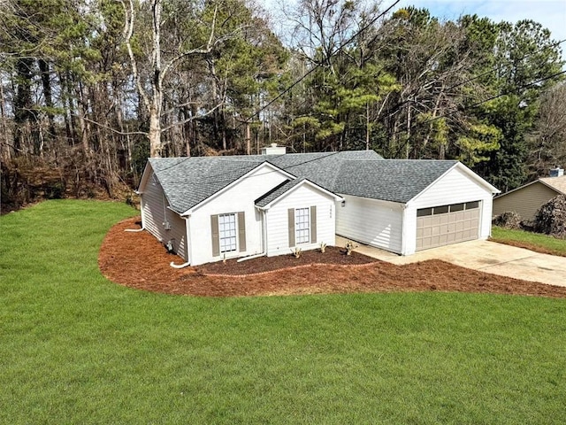 view of front of house with a garage, roof with shingles, concrete driveway, and a front yard