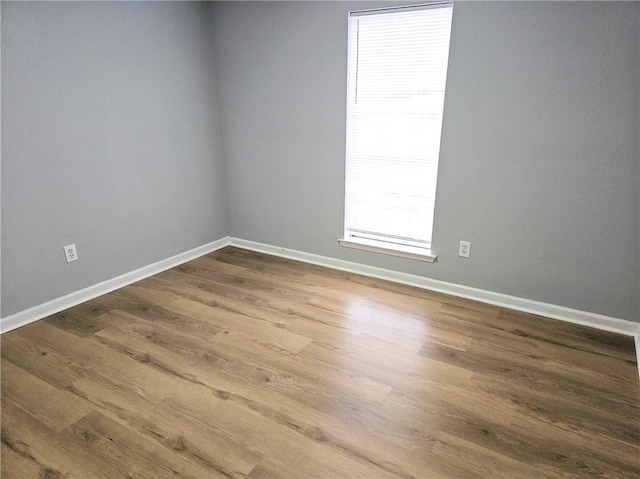 spare room featuring wood finished floors and baseboards