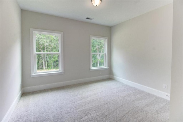 spare room with baseboards, visible vents, and carpet flooring