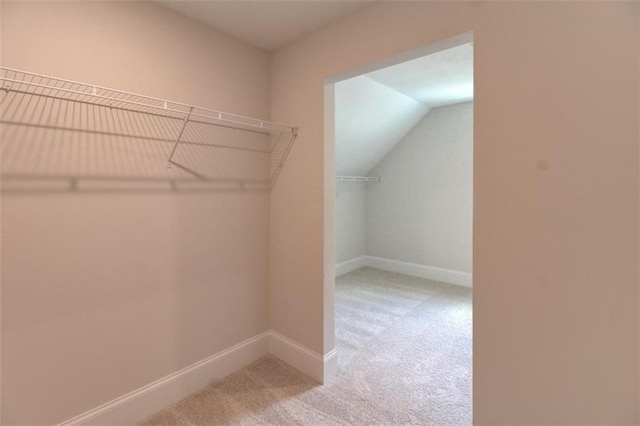 spacious closet with carpet floors and lofted ceiling