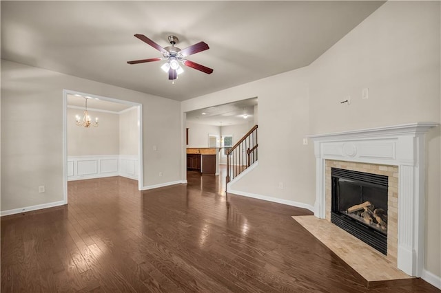 559 Myrle Trace Ln, Suwanee, GA 30024 - unfurnished living room with a tiled fireplace, a ceiling fan, a chandelier, stairs, and dark wood finished floors