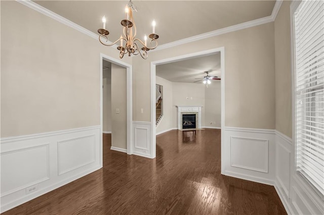 559 Myrle Trace Ln, Suwanee, GA 30024 - unfurnished dining area featuring a chandelier, a fireplace with flush hearth, a wainscoted wall, ceiling fan, and dark wood-type flooring