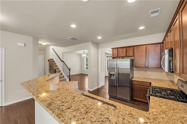 559 Myrle Trace Ln, Suwanee, GA 30024 - kitchen with appliances with stainless steel finishes, light stone counters, dark wood finished floors, backsplash, and ceiling fan