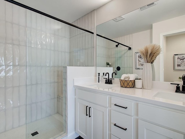 bathroom with double vanity, visible vents, a shower stall, and a sink