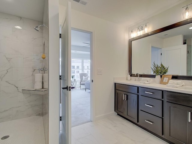 bathroom with vanity and tiled shower