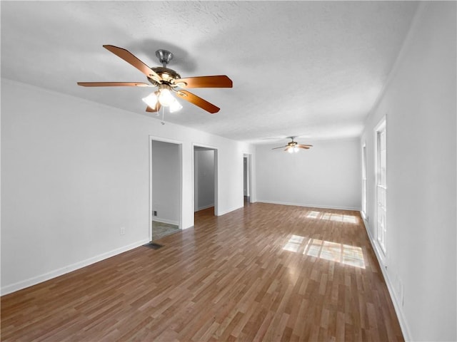 8005 Bamby Ln, Jonesboro, GA 30236 - empty room with visible vents, a ceiling fan, a textured ceiling, wood finished floors, and baseboards