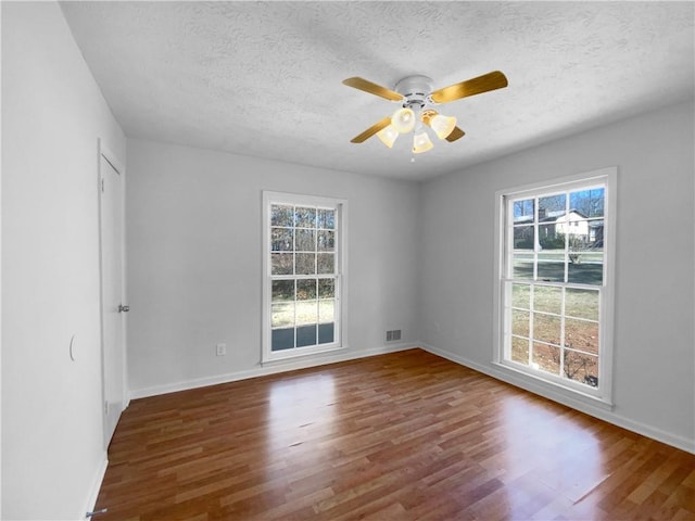 8005 Bamby Ln, Jonesboro, GA 30236 - empty room featuring dark wood-style flooring, plenty of natural light, and visible vents
