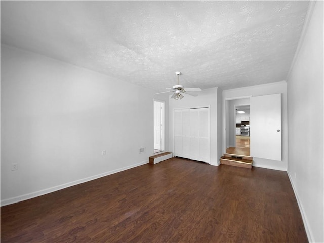 8005 Bamby Ln, Jonesboro, GA 30236 - empty room featuring ceiling fan, baseboards, dark wood finished floors, and a textured ceiling